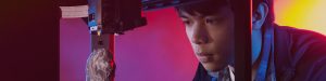 Young asian man watching a 3d printer print a lion figure